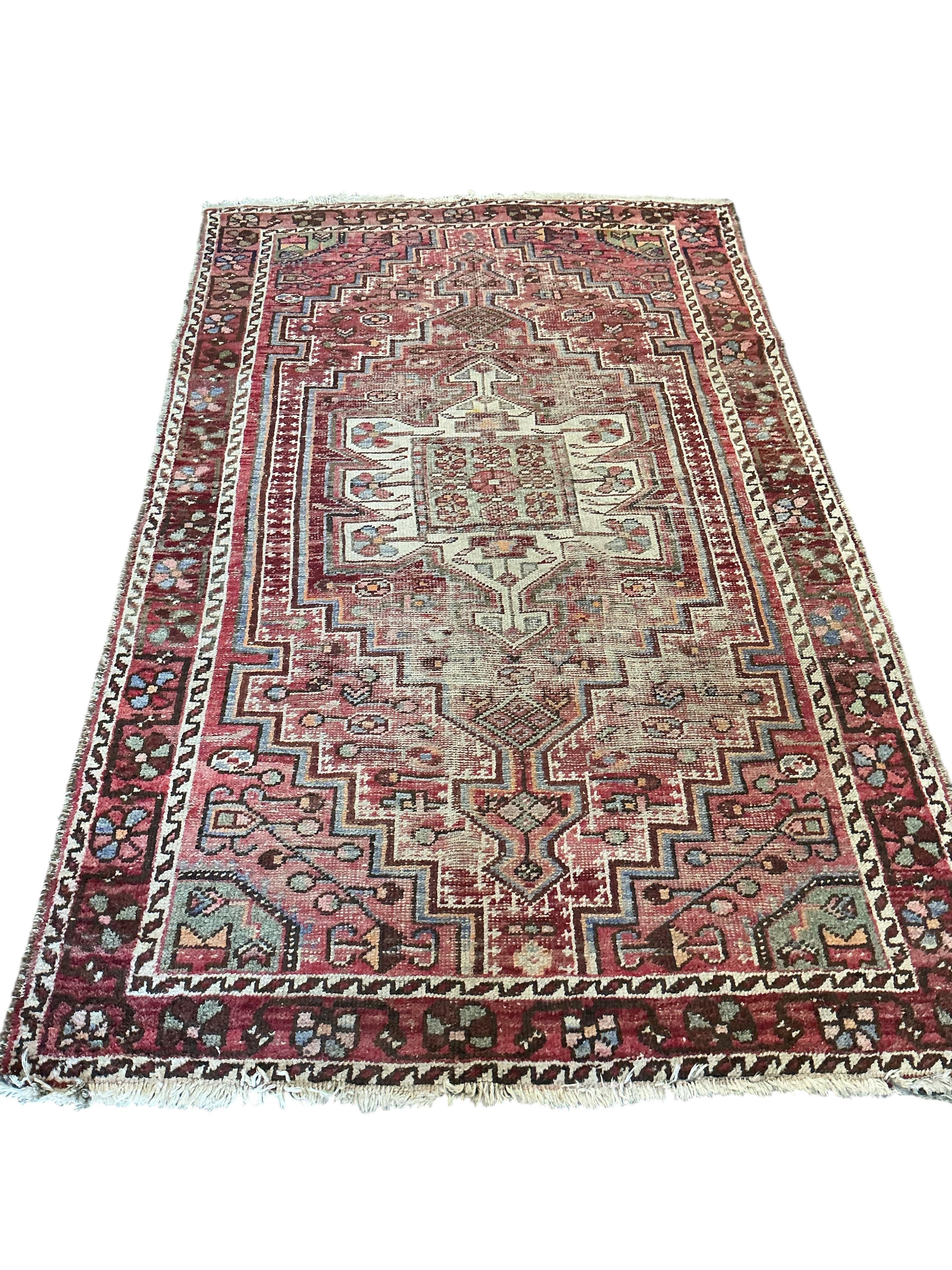 A Caucasian faded red ground rug, 210 x 126cm (severely worn)